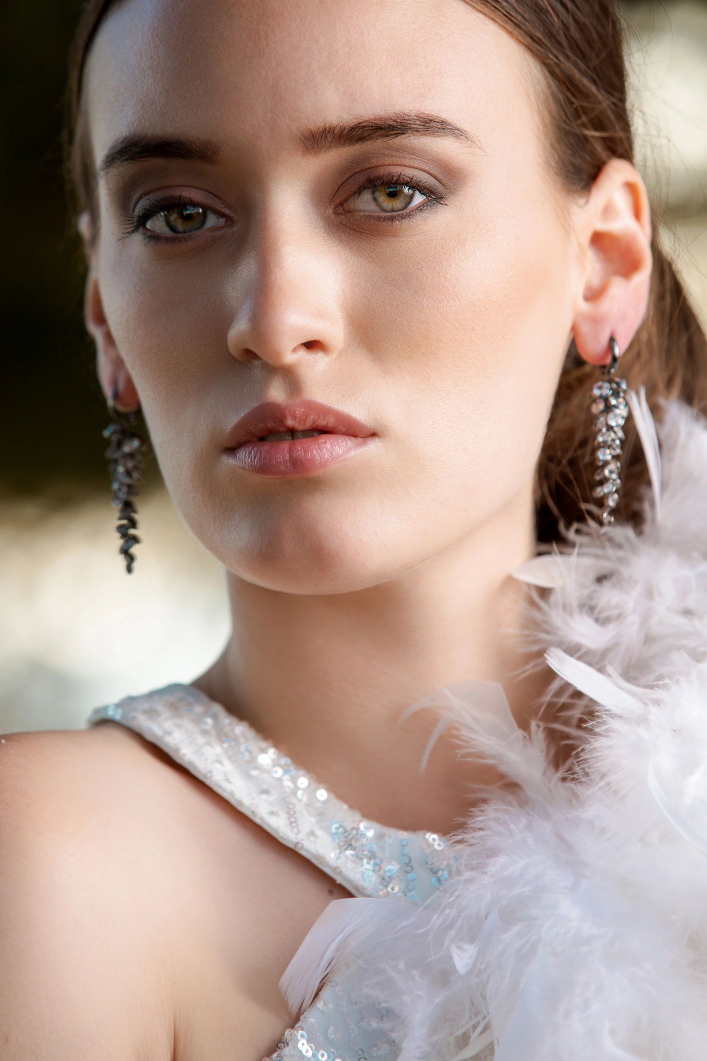 Retrato de belleza con detalle de plumas blancas