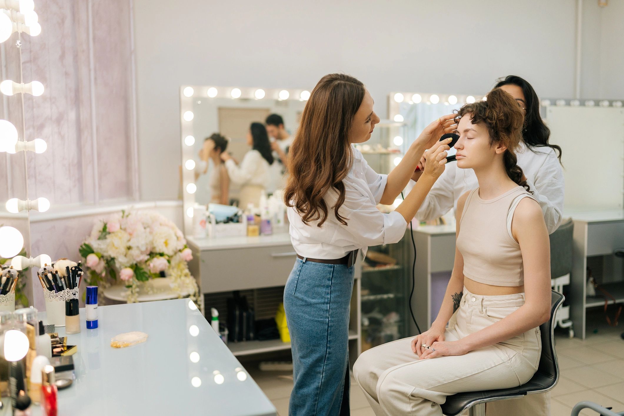 Equipo de belleza trabajando en peinado y maquillaje durante una producción